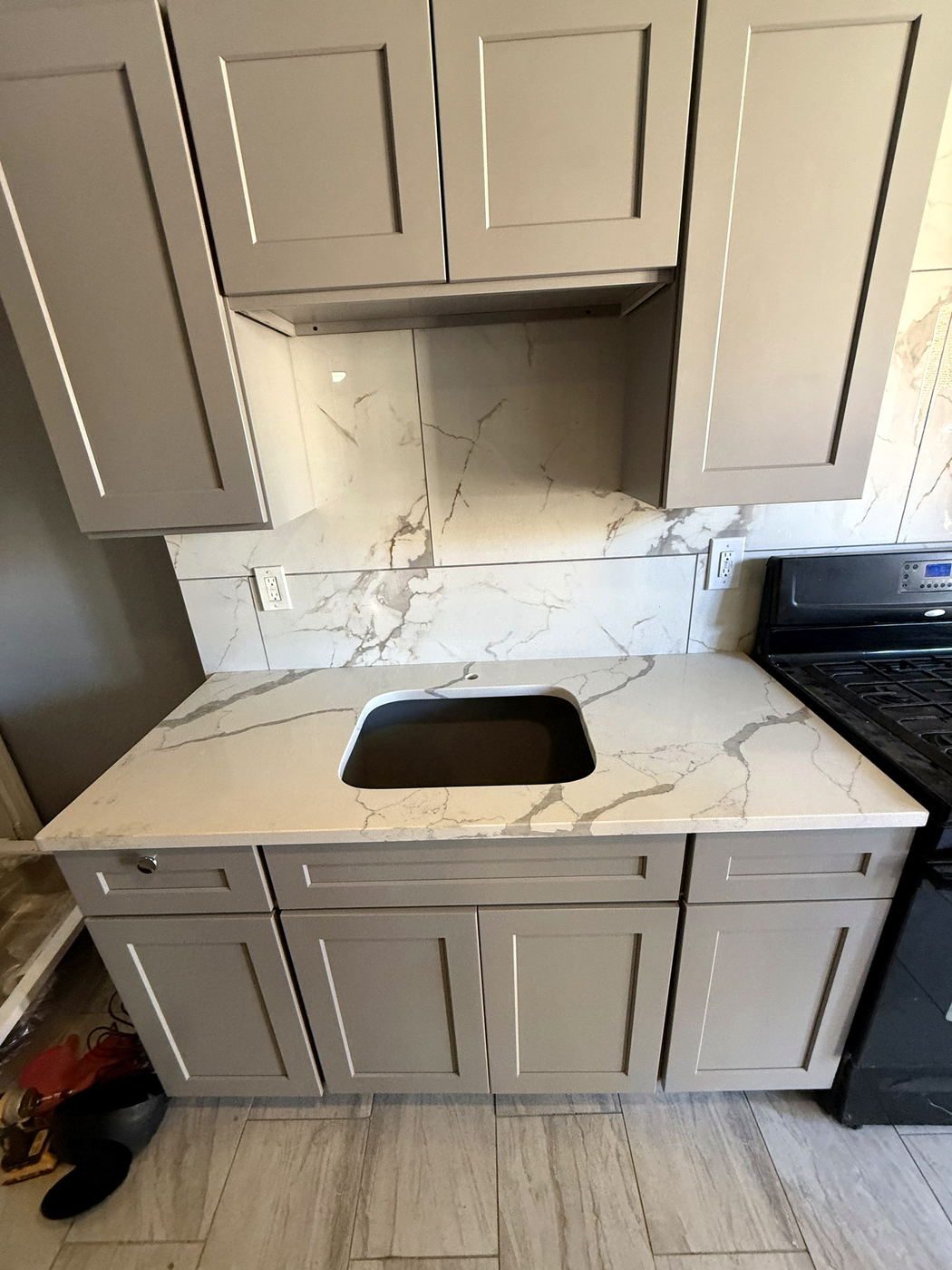 Quartz countertop with an undermount sink cutout and a full-height stone backsplash