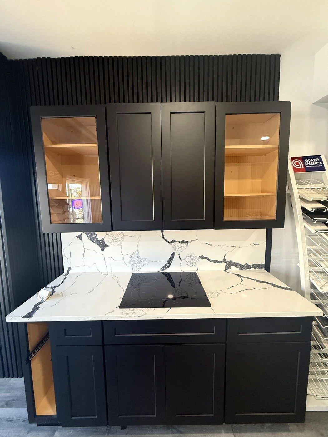 Matte black island with a veined quartz countertop