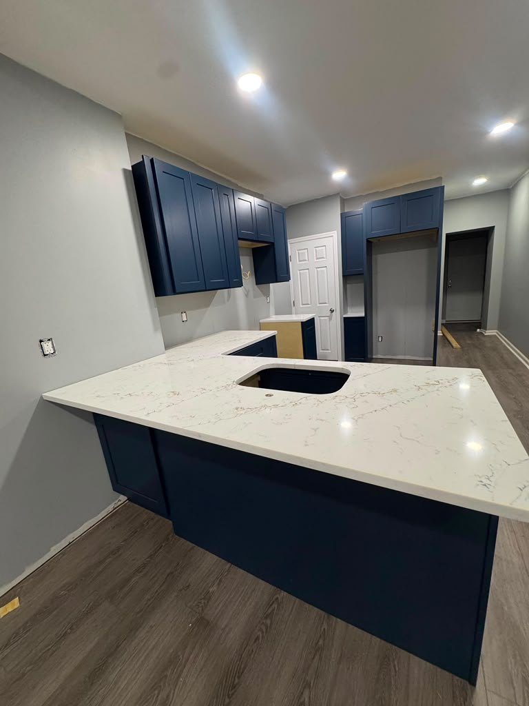 The same peninsula finished with a veined white quartz top and undermount sink cutout