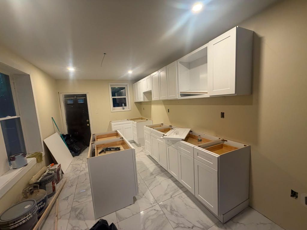 White shaker cabinets installed and levelled with open plywood tops, before the countertops