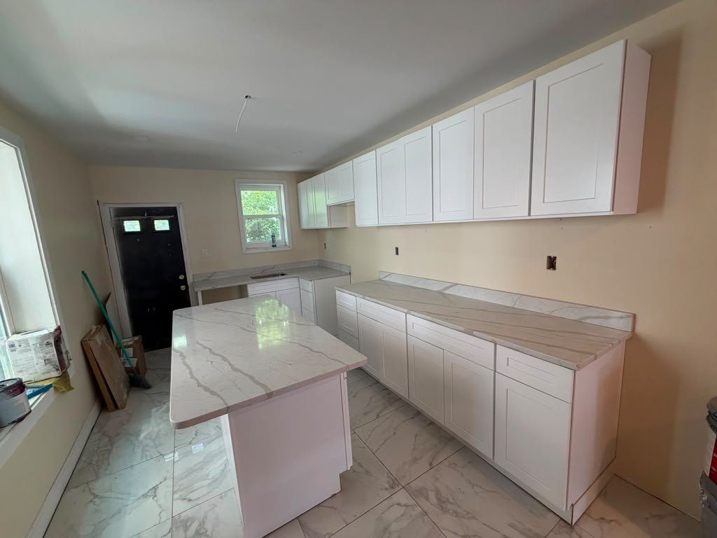 The same kitchen finished with marble-look quartz counters and a waterfall island end