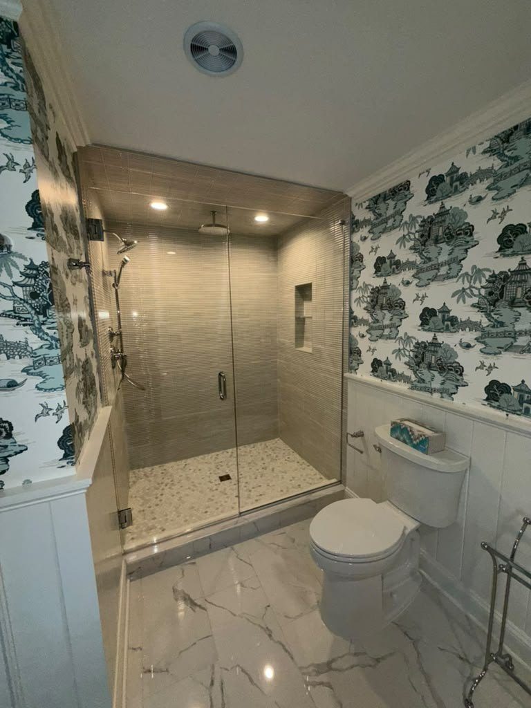 Bathroom with a marble-look stone floor and a stone bench inside the shower