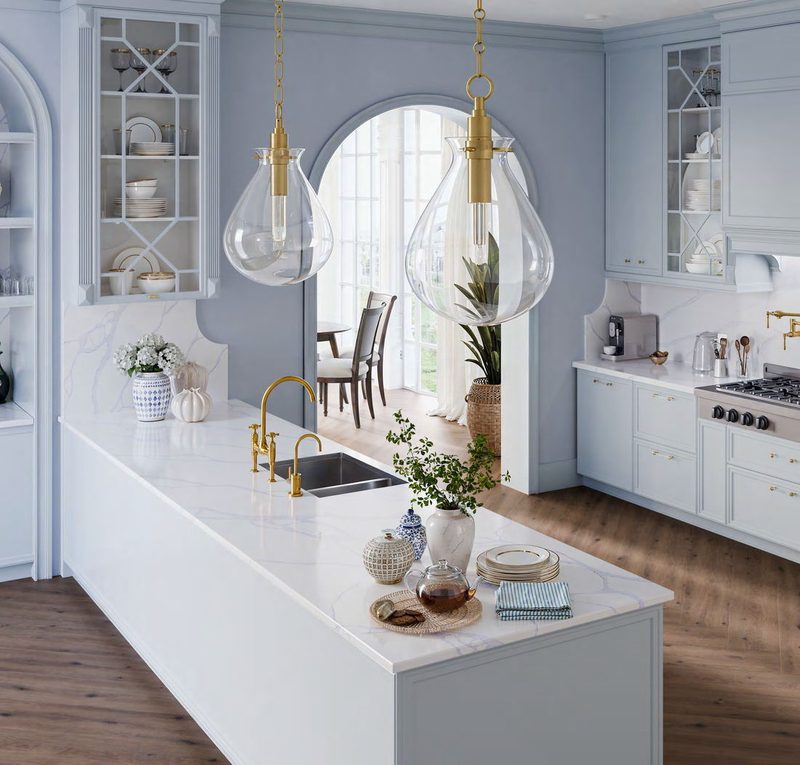 Pale blue kitchen with a long island and arched window